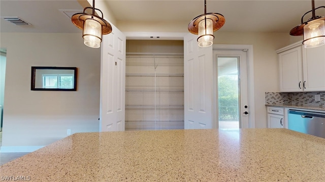 kitchen with white cabinetry, tasteful backsplash, dishwasher, light stone countertops, and decorative light fixtures