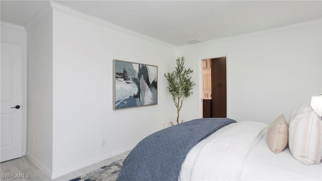 bedroom with ornamental molding, light hardwood / wood-style floors, and ensuite bathroom