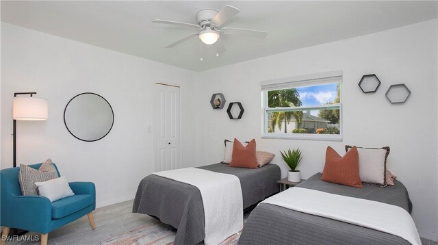 bedroom with ceiling fan, light wood-type flooring, and a closet