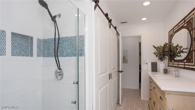 bathroom with walk in shower, vanity, and wood-type flooring