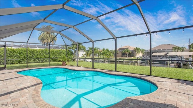 view of swimming pool with a patio, a lanai, and a yard