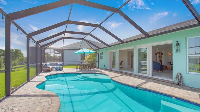 view of swimming pool with glass enclosure and a patio area