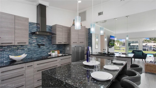 kitchen featuring crown molding, tasteful backsplash, hanging light fixtures, black electric cooktop, and wall chimney range hood