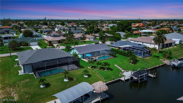 aerial view at dusk featuring a water view