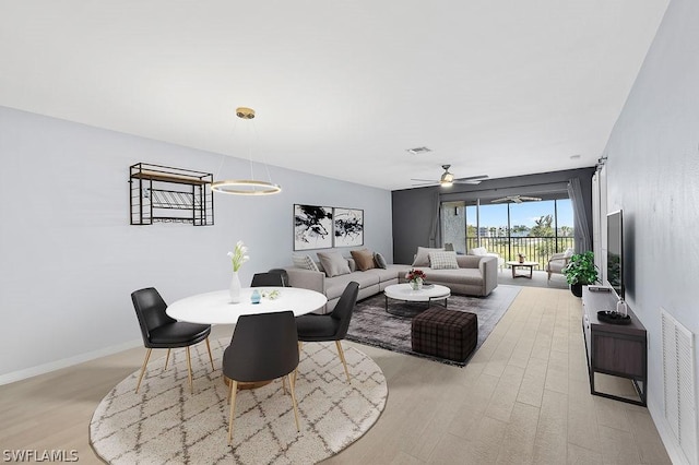 living area with light wood-style flooring, visible vents, and baseboards