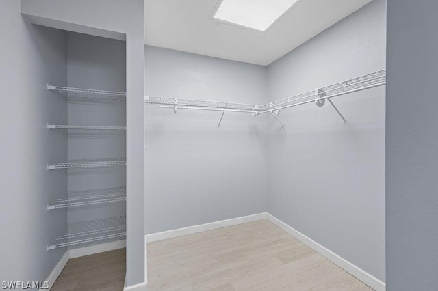 walk in closet with wood finished floors