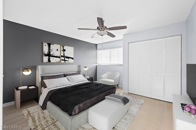 bedroom featuring a closet, ceiling fan, baseboards, and wood finished floors