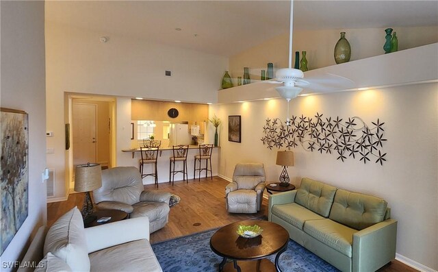 living room with high vaulted ceiling and wood-type flooring