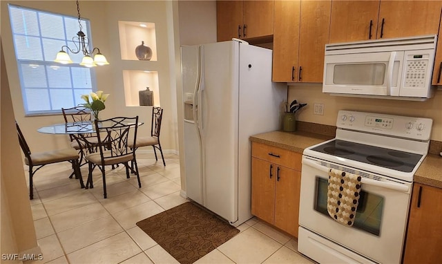 kitchen with light tile patterned floors, a chandelier, white appliances, brown cabinets, and pendant lighting