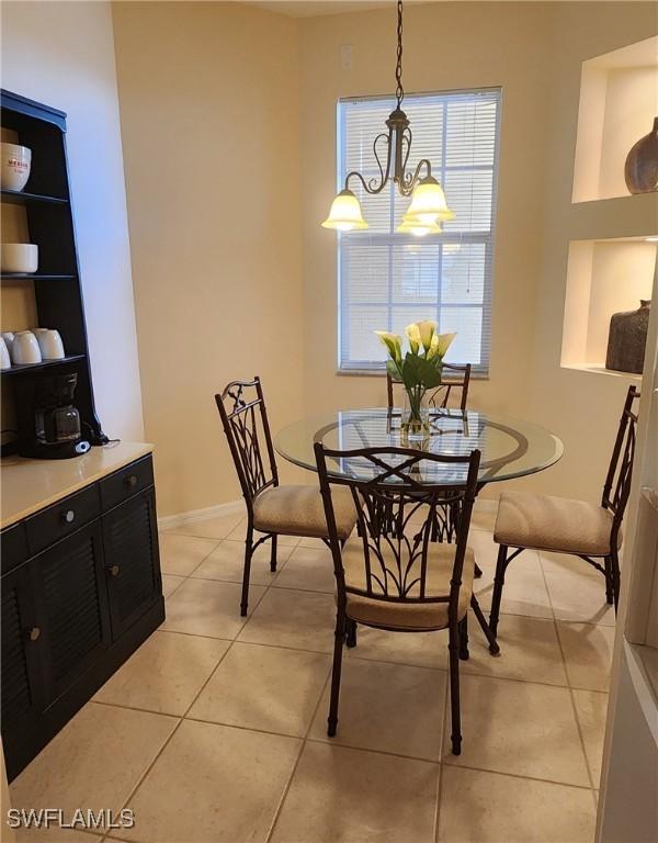 tiled dining room with built in shelves and an inviting chandelier