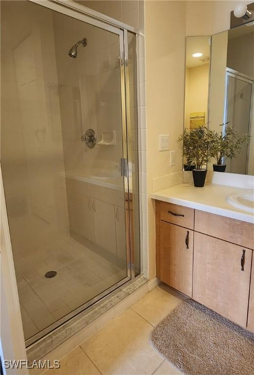 bathroom featuring tile patterned flooring, vanity, and an enclosed shower