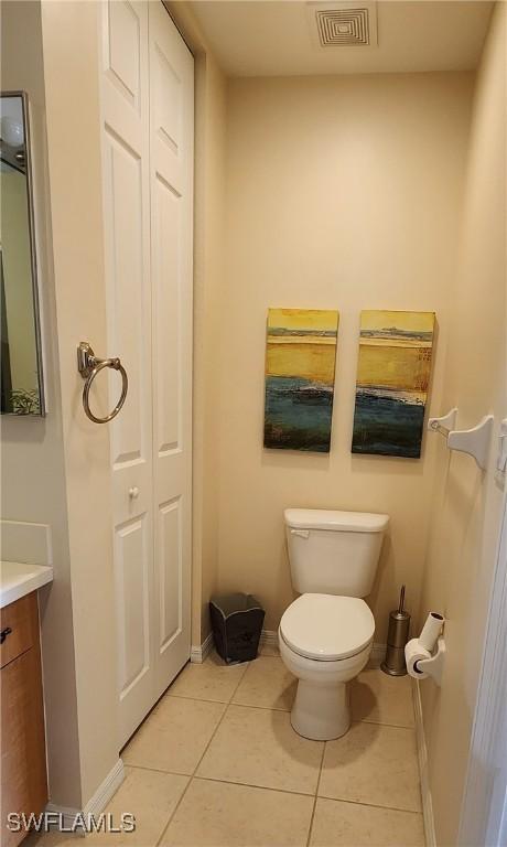 bathroom with tile patterned flooring, toilet, vanity, visible vents, and baseboards