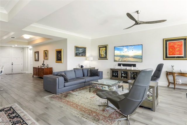 living room with ornamental molding, light wood-type flooring, and ceiling fan