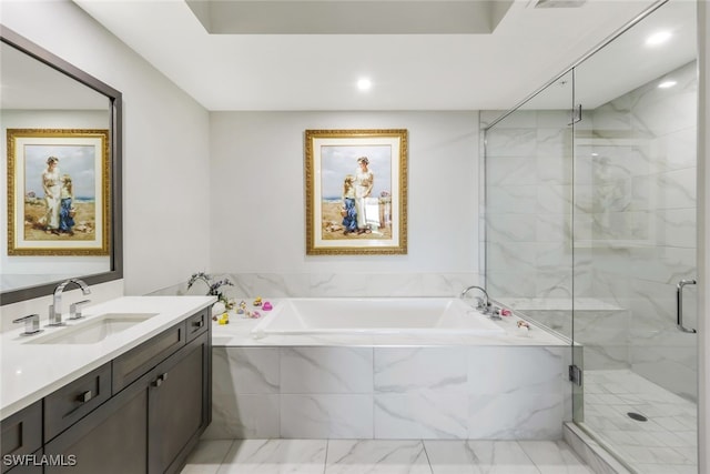 bathroom with vanity and shower with separate bathtub