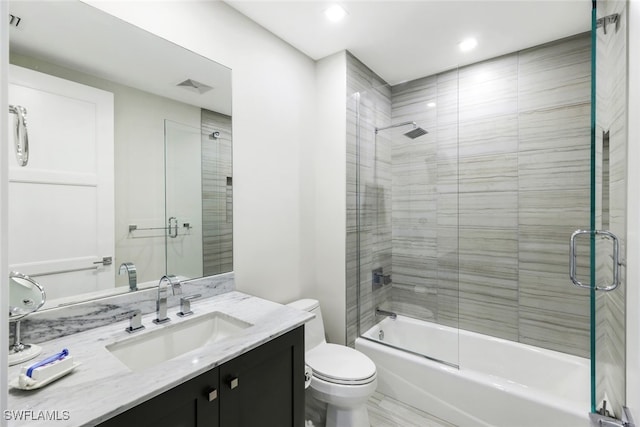 full bathroom featuring shower / bath combination with glass door, vanity, and toilet