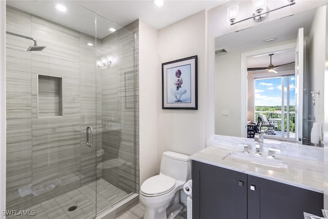 bathroom featuring ceiling fan, an enclosed shower, vanity, and toilet