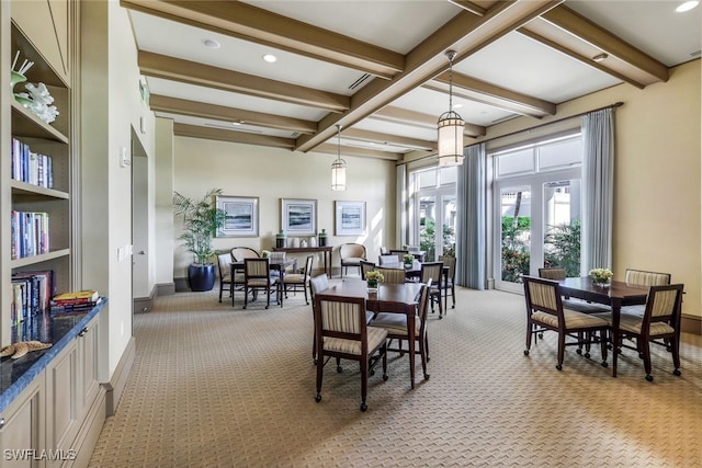 dining area featuring beam ceiling and light colored carpet