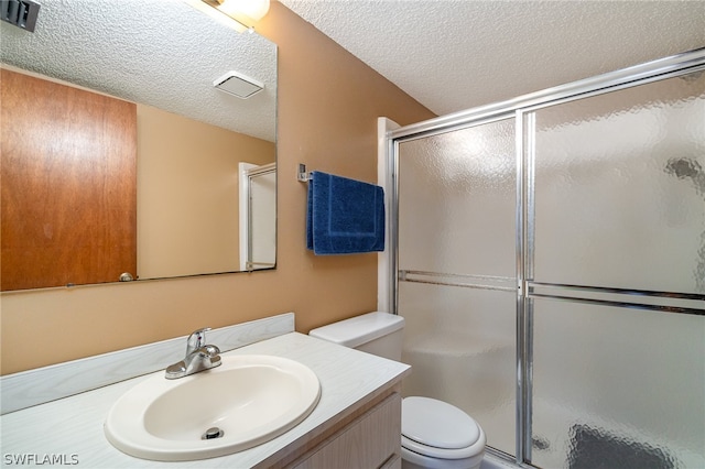 bathroom featuring an enclosed shower, toilet, vanity, and a textured ceiling