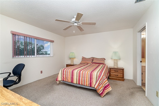 bedroom with carpet floors, a textured ceiling, ceiling fan, and connected bathroom