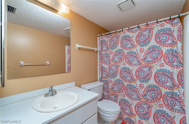 bathroom featuring vanity, toilet, and a textured ceiling