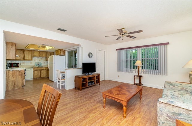 living room with light hardwood / wood-style floors and ceiling fan