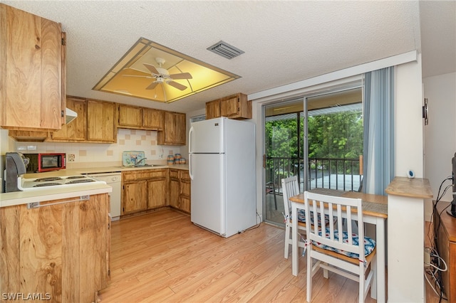 kitchen with ceiling fan, white appliances, sink, light hardwood / wood-style flooring, and a textured ceiling