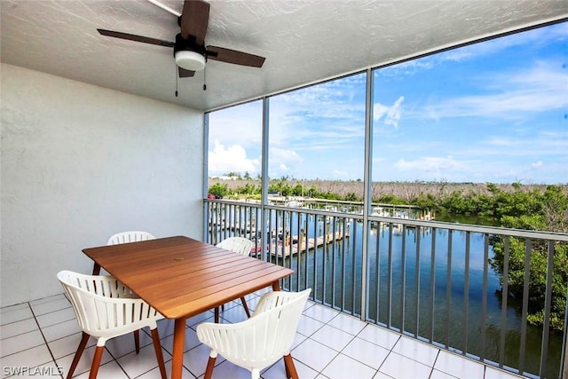 sunroom featuring a water view