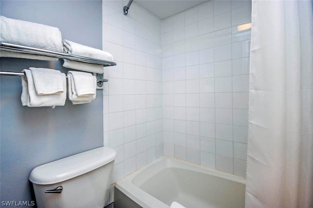 bathroom featuring toilet and shower / bath combination with curtain