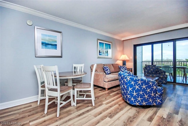 living area with wood finished floors, baseboards, and ornamental molding