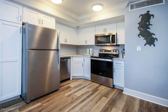 kitchen with crown molding, light countertops, appliances with stainless steel finishes, and a sink