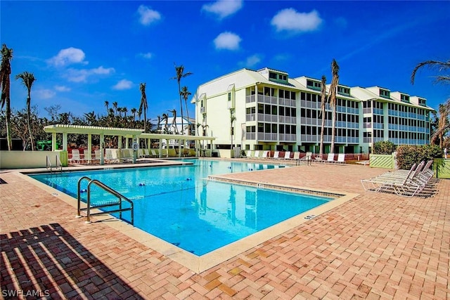pool with a patio area and a pergola