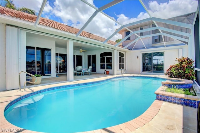 view of swimming pool with a lanai, a patio area, a hot tub, and ceiling fan