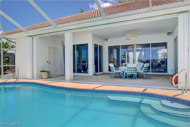 view of swimming pool with a patio area, ceiling fan, and glass enclosure