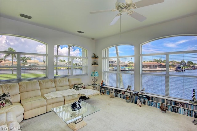 sunroom / solarium featuring a water view and ceiling fan