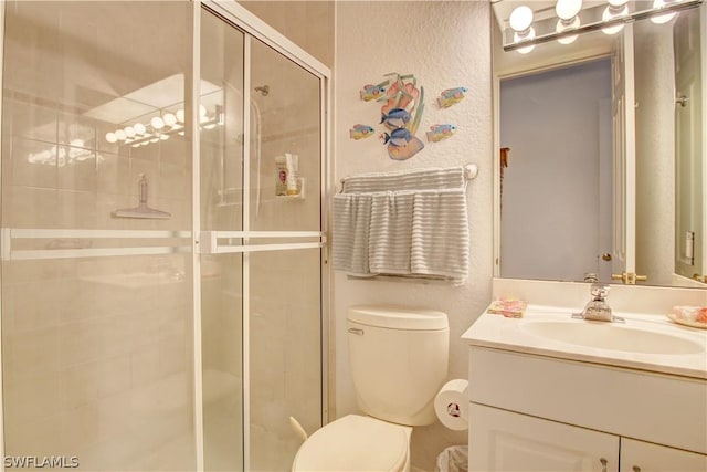 bathroom with an enclosed shower, vanity, and toilet