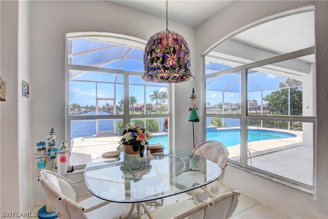 dining area featuring a water view and tile patterned flooring