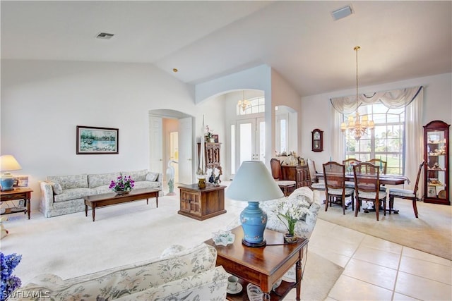 carpeted living room featuring french doors, lofted ceiling, and a chandelier