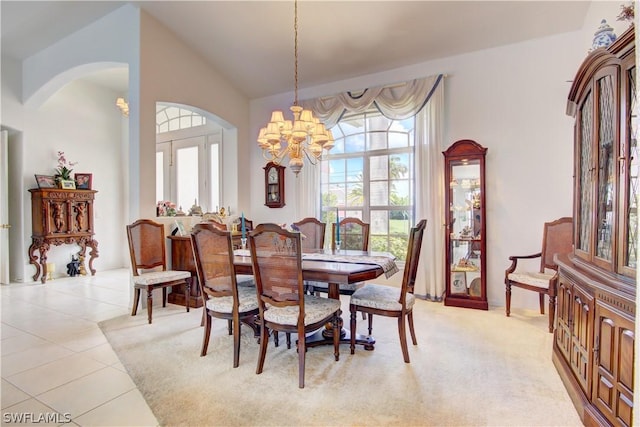 tiled dining area with a chandelier and high vaulted ceiling