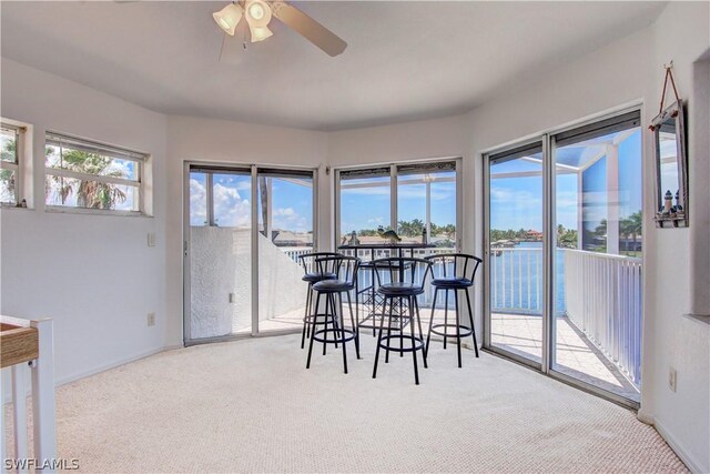 carpeted dining area featuring ceiling fan