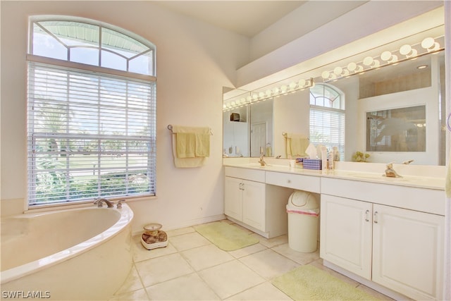 bathroom with dual vanity, a tub to relax in, and tile patterned floors