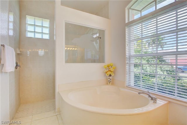 bathroom featuring a washtub, a healthy amount of sunlight, and tile patterned flooring