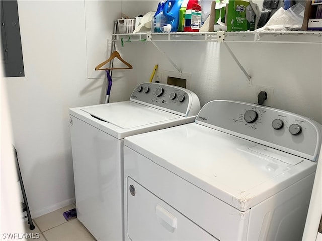 laundry area featuring light tile patterned flooring, electric panel, and washing machine and dryer