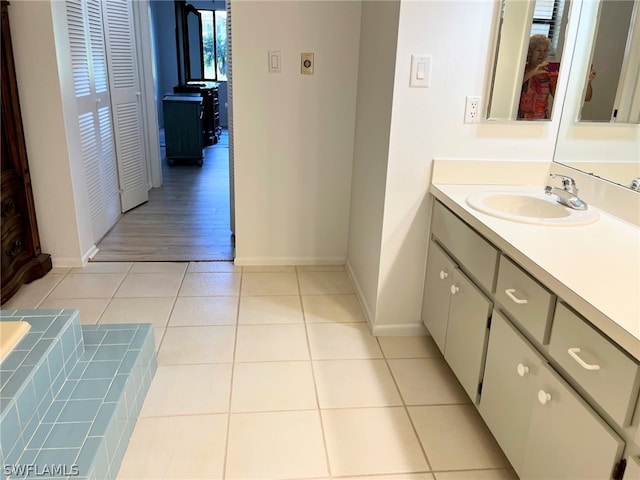 bathroom featuring vanity, wood-type flooring, and tiled bath