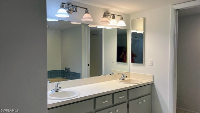 bathroom featuring dual bowl vanity and a bathtub