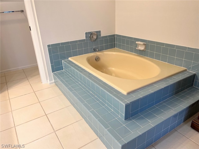 bathroom featuring tiled tub and tile patterned flooring