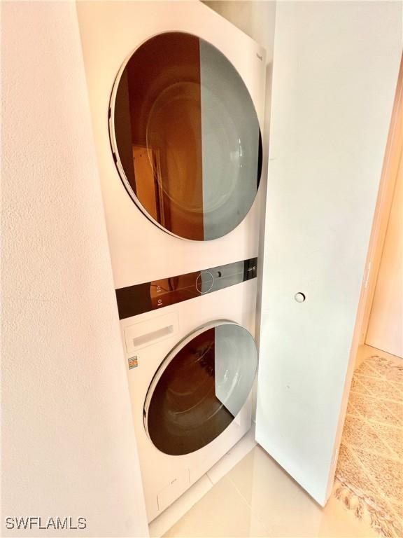 3000 Oasis Grand Blvd Unit 1606, Fort Myers, FL 33916 - laundry room featuring tile patterned flooring and stacked washer and clothes dryer