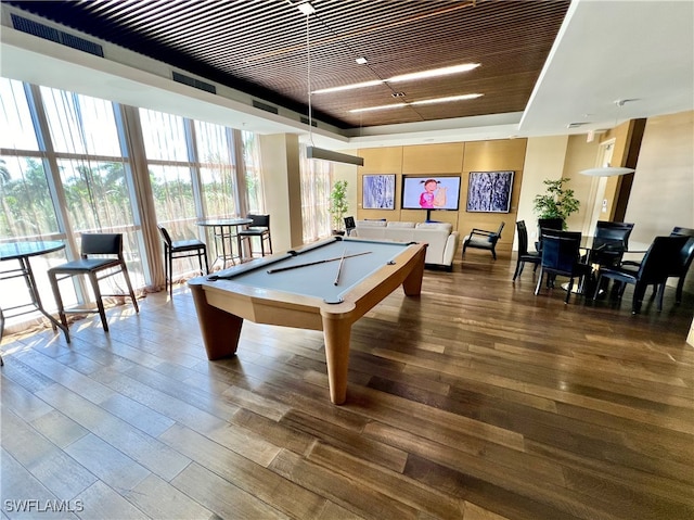 recreation room with billiards, a raised ceiling, floor to ceiling windows, and wood-type flooring