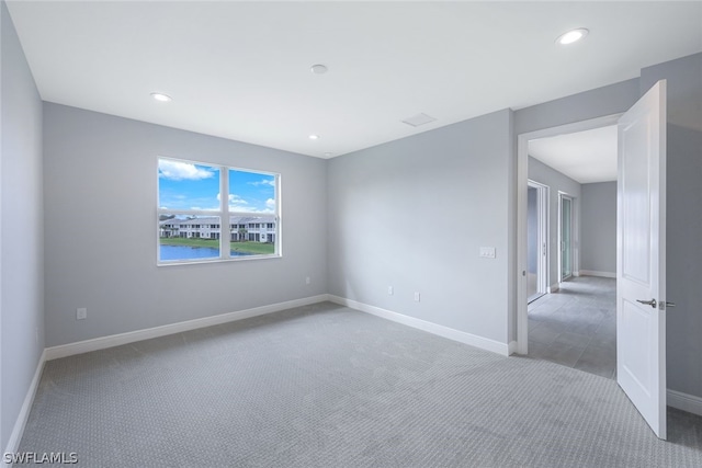 carpeted empty room featuring recessed lighting and baseboards