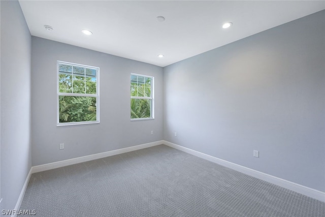 spare room featuring carpet floors, recessed lighting, and baseboards