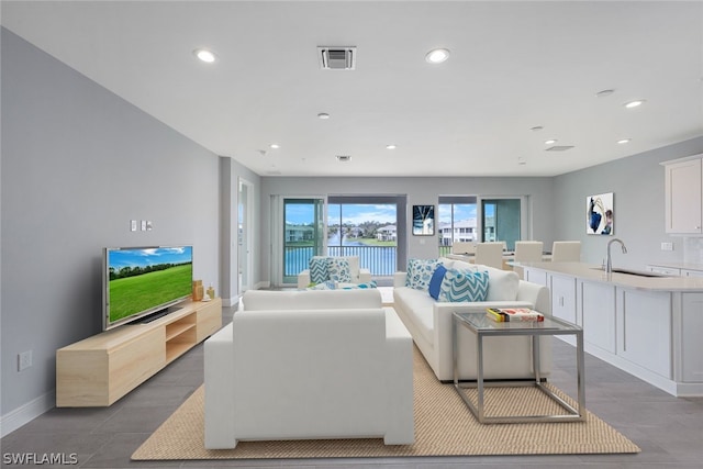 living area featuring baseboards, visible vents, and recessed lighting